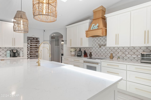 kitchen with decorative light fixtures, white range oven, sink, and tasteful backsplash