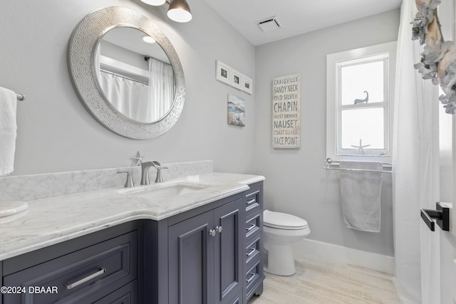 bathroom with toilet, vanity, and hardwood / wood-style flooring