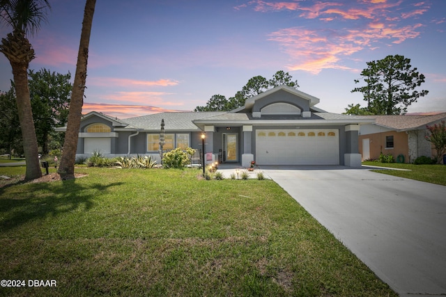 view of front of home featuring a lawn and a garage