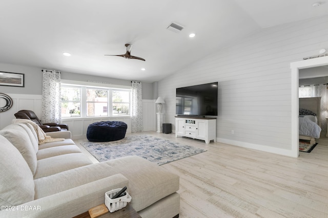 living room featuring ceiling fan, light hardwood / wood-style flooring, and lofted ceiling