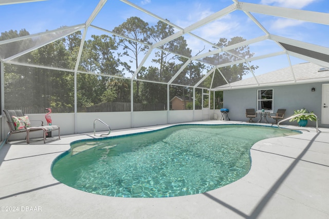 view of swimming pool with a patio area and a lanai