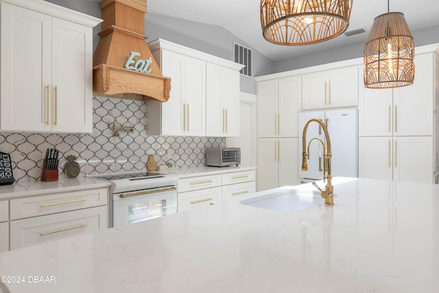 kitchen featuring white cabinets, range, tasteful backsplash, and pendant lighting