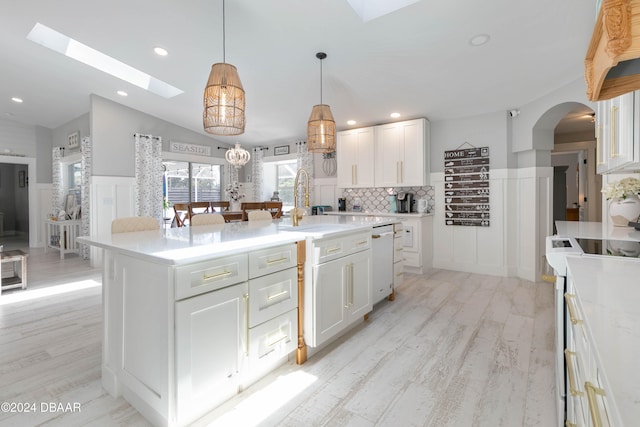 kitchen with a center island, white cabinets, white appliances, and light wood-type flooring