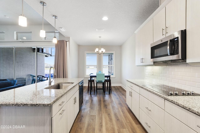 kitchen featuring pendant lighting, appliances with stainless steel finishes, sink, and wood-type flooring