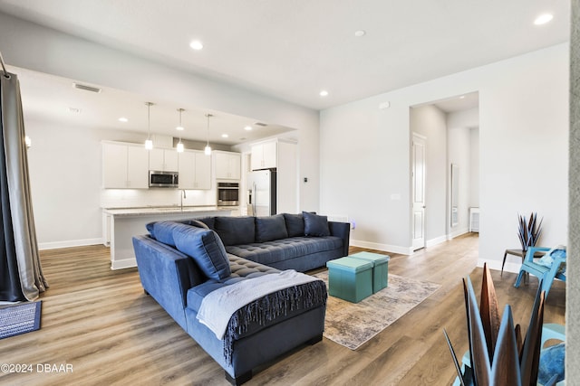 living room featuring light hardwood / wood-style floors and sink