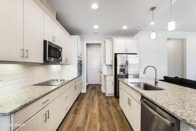 kitchen featuring light stone counters, appliances with stainless steel finishes, dark hardwood / wood-style floors, sink, and white cabinets