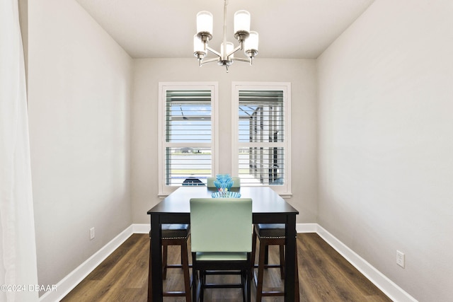 dining room with dark hardwood / wood-style flooring and a notable chandelier