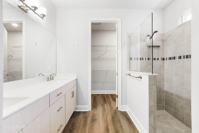 bathroom with vanity, hardwood / wood-style flooring, and a tile shower