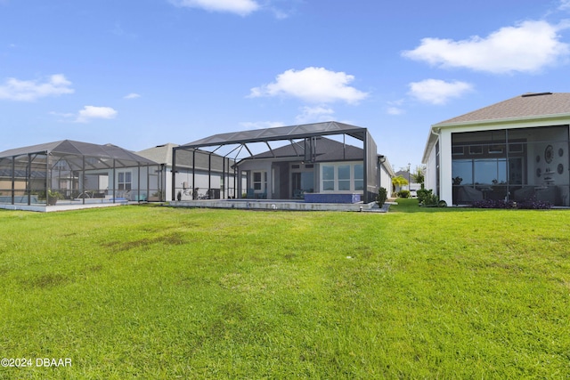 rear view of property featuring a lawn, a lanai, a pool, and a patio area