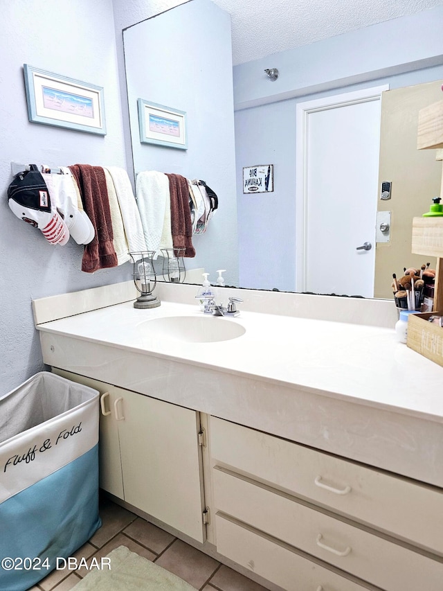 bathroom featuring tile patterned flooring, vanity, and a textured ceiling