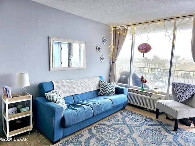 living room featuring tile patterned flooring, a textured ceiling, and a wall mounted air conditioner