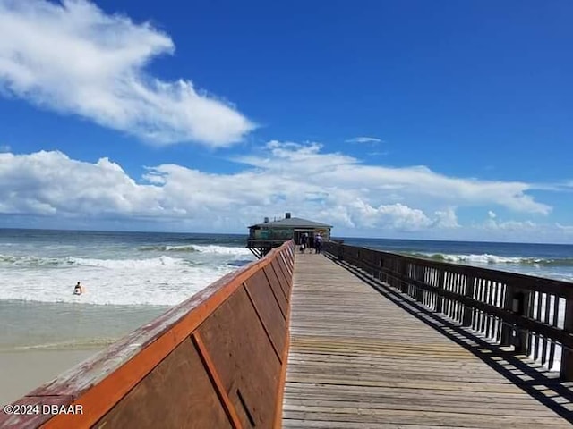 dock area featuring a water view and a view of the beach