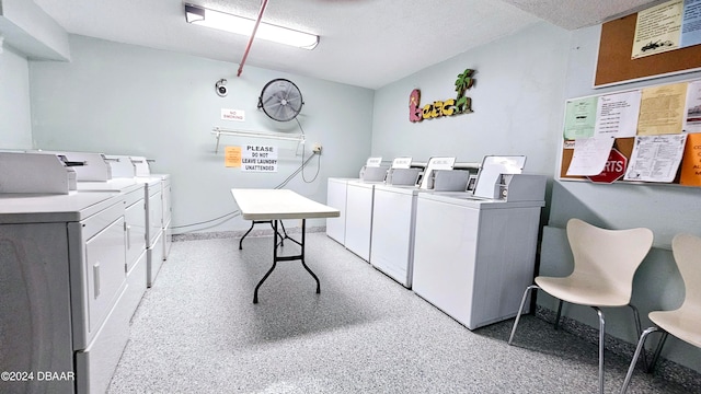 clothes washing area with a textured ceiling and washer and clothes dryer