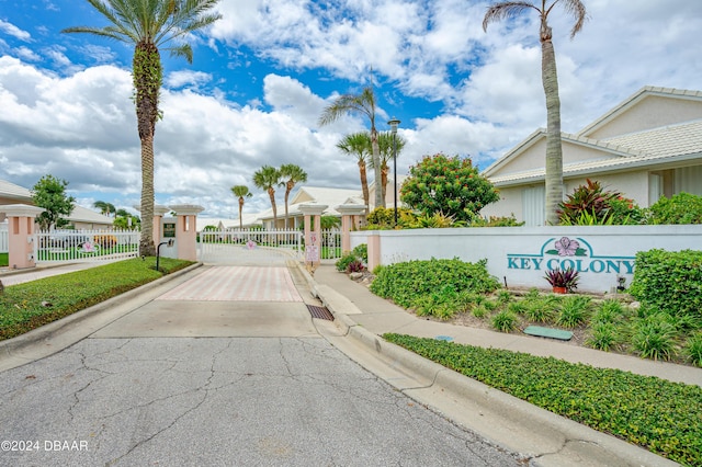 151 Key Colony Ct, Daytona Beach, FL 32118 - view of asphalt street with curbs, sidewalks, a gate, a gated entry, and street lighting