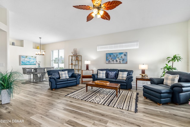 living room with ceiling fan with notable chandelier and light wood-type flooring