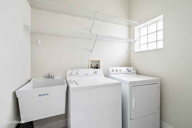 washroom with separate washer and dryer and sink