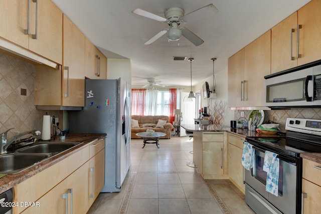 kitchen featuring stainless steel appliances, sink, light tile patterned floors, light brown cabinets, and decorative light fixtures