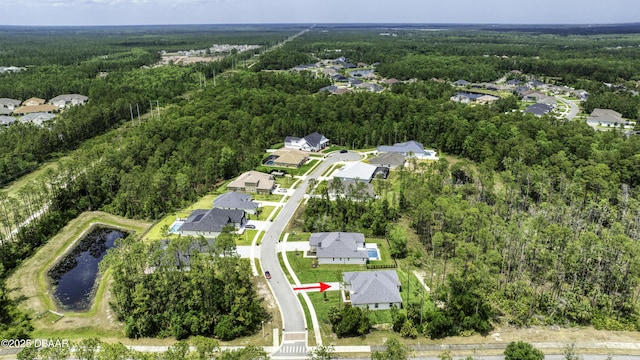 aerial view of property's location featuring a heavily wooded area, nearby suburban area, and a nearby body of water