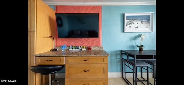 interior space featuring ornamental molding and stone countertops