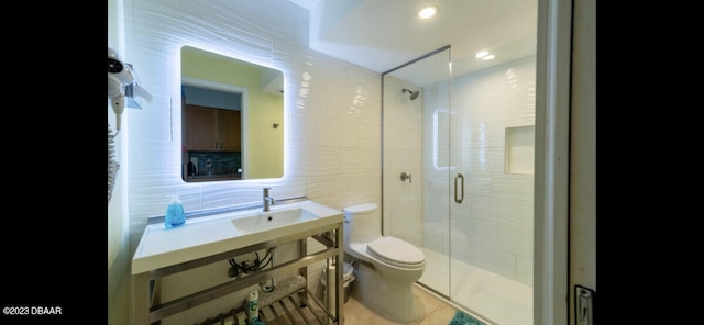 bathroom with tile walls, tile patterned floors, a shower with door, backsplash, and toilet