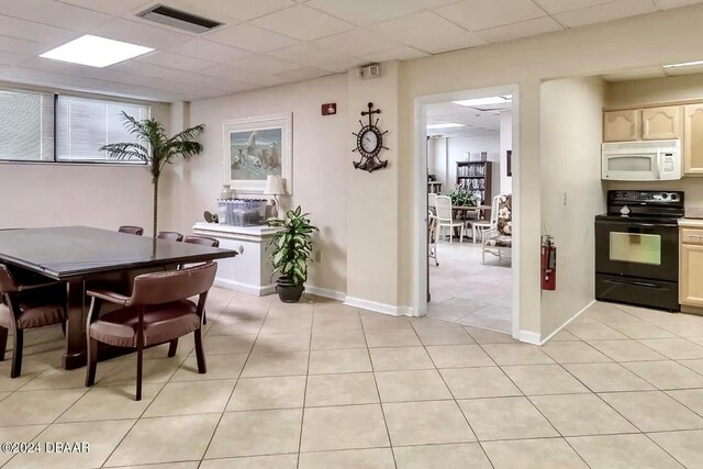 interior space featuring light tile patterned flooring and a drop ceiling