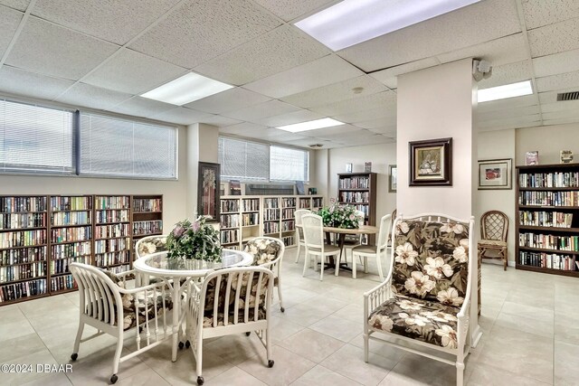 tiled dining room featuring a paneled ceiling