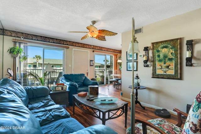 living room featuring hardwood / wood-style flooring, ceiling fan, a healthy amount of sunlight, and a textured ceiling