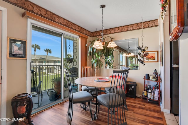 dining area with hardwood / wood-style flooring and a notable chandelier