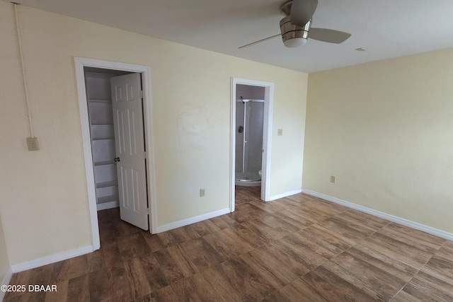 unfurnished bedroom with a walk in closet, connected bathroom, dark hardwood / wood-style floors, a closet, and ceiling fan