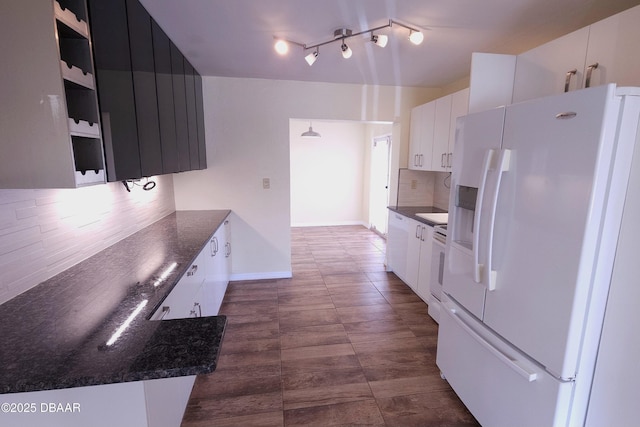 kitchen with white fridge with ice dispenser, white cabinets, and decorative backsplash