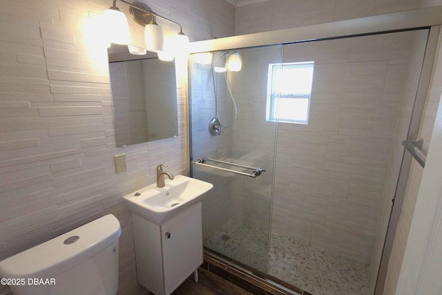 bathroom with toilet, tile walls, walk in shower, and vanity