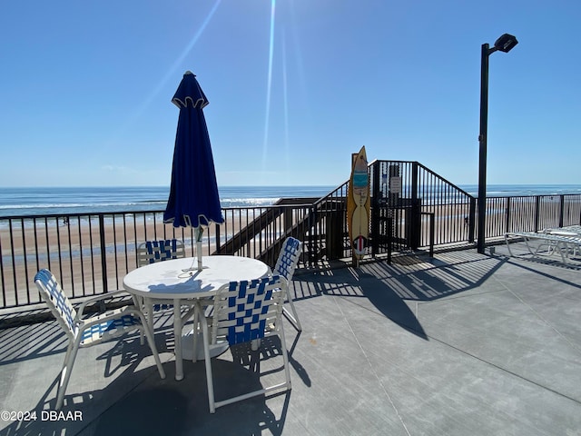 view of patio featuring a water view and a view of the beach