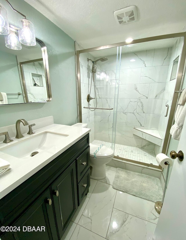 bathroom with a shower with door, vanity, toilet, and a textured ceiling