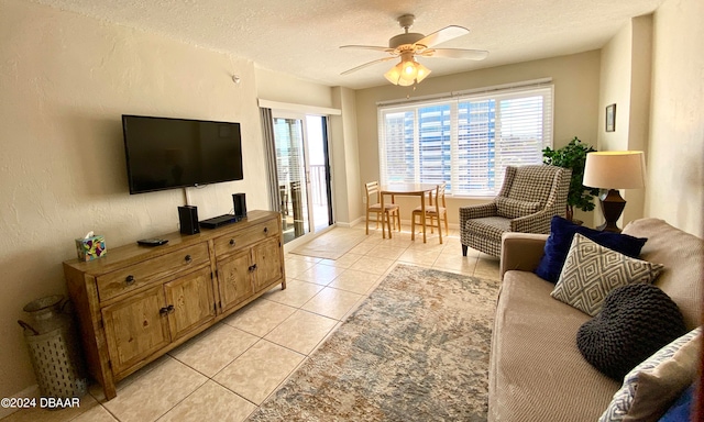 living room featuring a textured ceiling, light tile patterned flooring, and ceiling fan