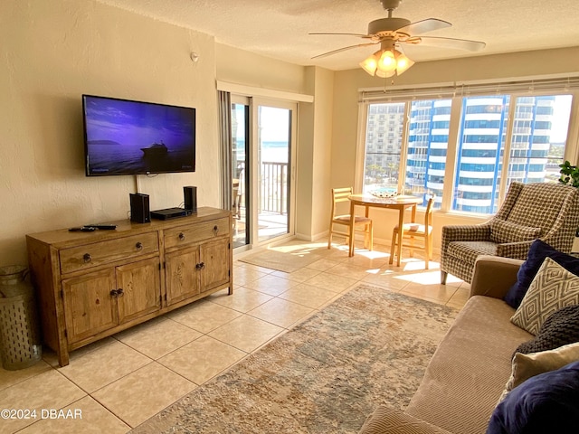 living room with a textured ceiling, light tile patterned flooring, and ceiling fan