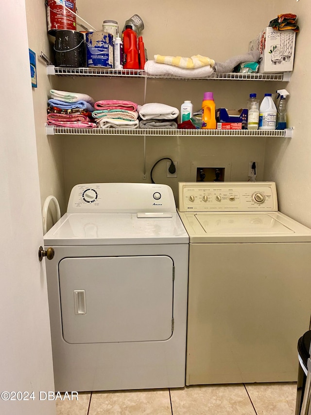 laundry room featuring light tile patterned flooring and separate washer and dryer