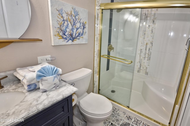 bathroom featuring toilet, vanity, and a shower with shower door