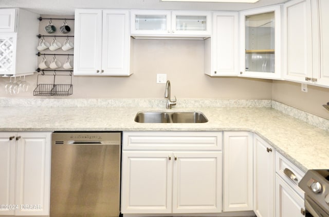 kitchen with stove, white cabinetry, sink, and dishwasher