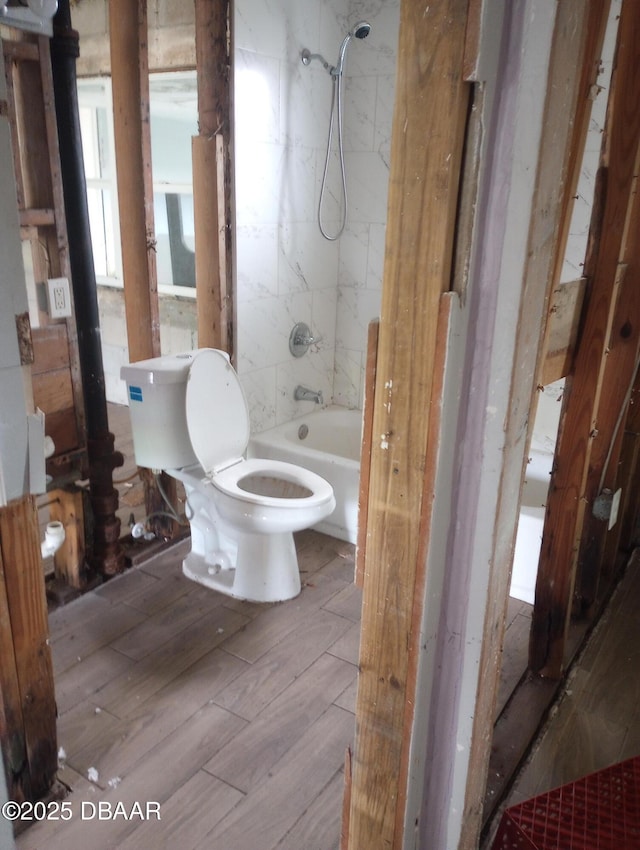 bathroom featuring toilet and tiled shower / bath