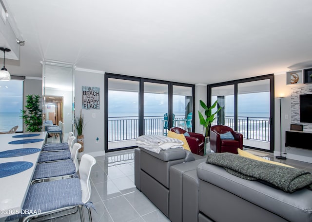 living room featuring light tile patterned flooring, plenty of natural light, crown molding, and a water view