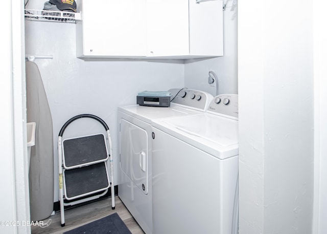 clothes washing area featuring light hardwood / wood-style floors, cabinets, and independent washer and dryer