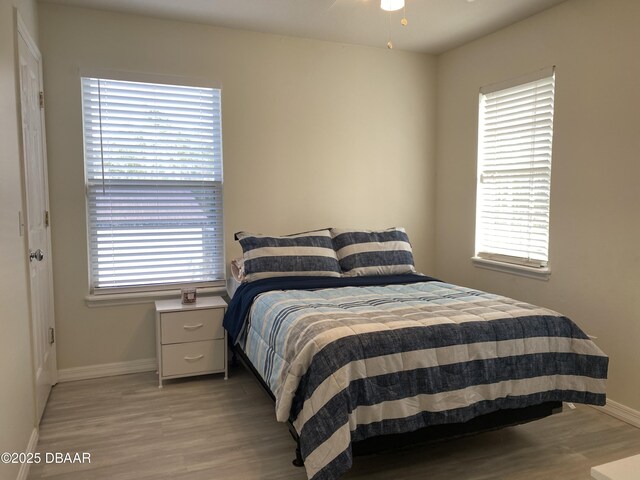 bedroom with vaulted ceiling, a textured ceiling, and light hardwood / wood-style flooring