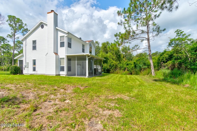 rear view of house with a sunroom and a yard