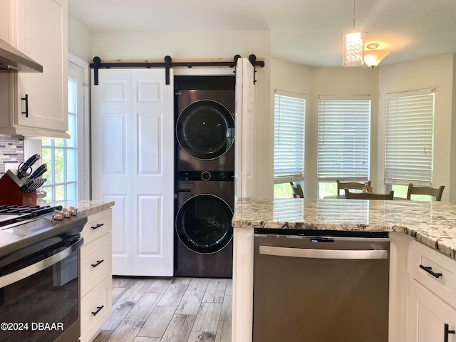 kitchen with white cabinets, stainless steel appliances, and stacked washer and clothes dryer