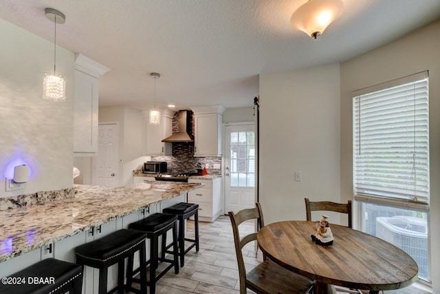 dining room with light hardwood / wood-style floors and a textured ceiling