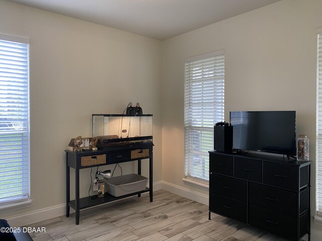 bedroom with light wood-type flooring, multiple windows, and ceiling fan