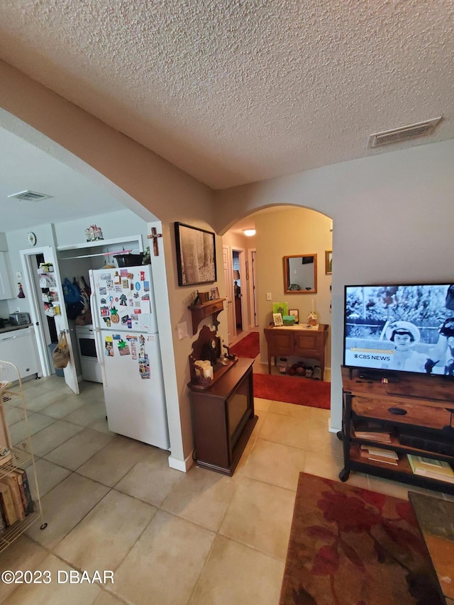 interior space with a textured ceiling and light tile patterned floors