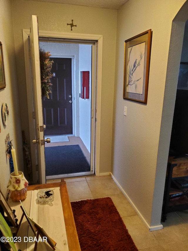 doorway to outside with light tile patterned flooring