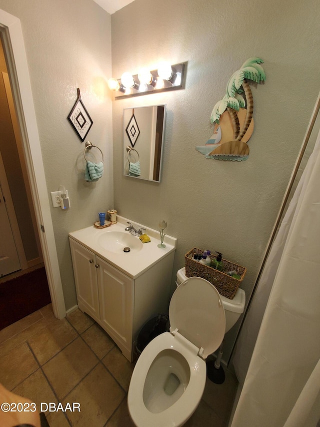 bathroom with tile patterned flooring, vanity, and toilet