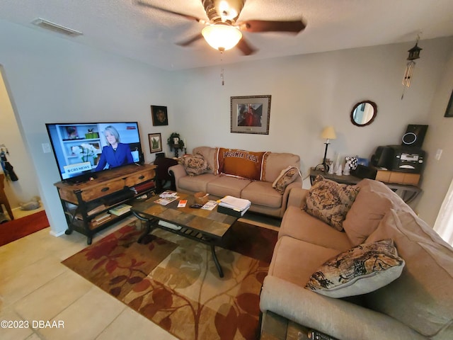 living room featuring a textured ceiling, tile patterned floors, and ceiling fan